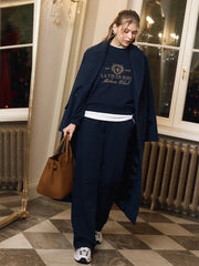 Person wearing a navy outfit with a brown bag in an indoor setting