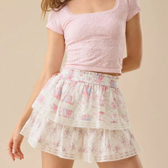 Person wearing a pink lace top and floral skirt on a beige background