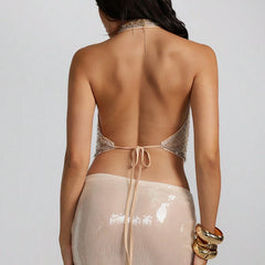 Woman wearing a beige and gold open-back top