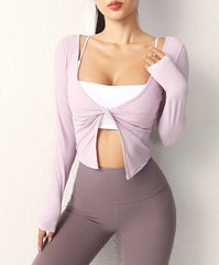 Person wearing a light purple long-sleeve top with a knot detail and gray leggings