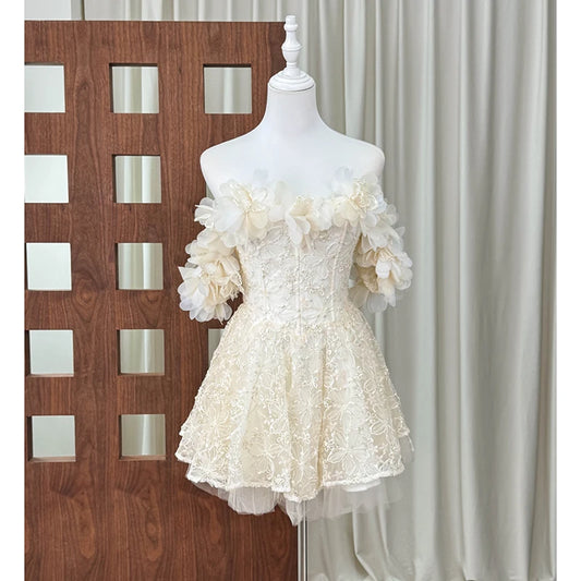 Off-shoulder mini dress with 3D ivory floral embellishments and lace overlay, displayed on a mannequin.