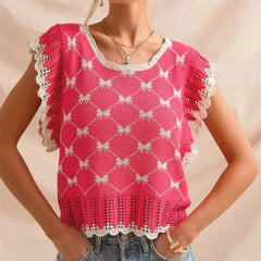 Pink knitted top with white lace details on a beige background
