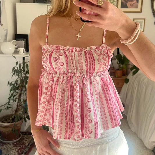 Person wearing a pink and white patterned top in a casual indoor setting.