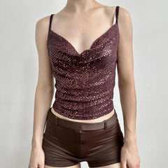 Mannequin wearing a sparkly purple top and brown shorts on a plain background