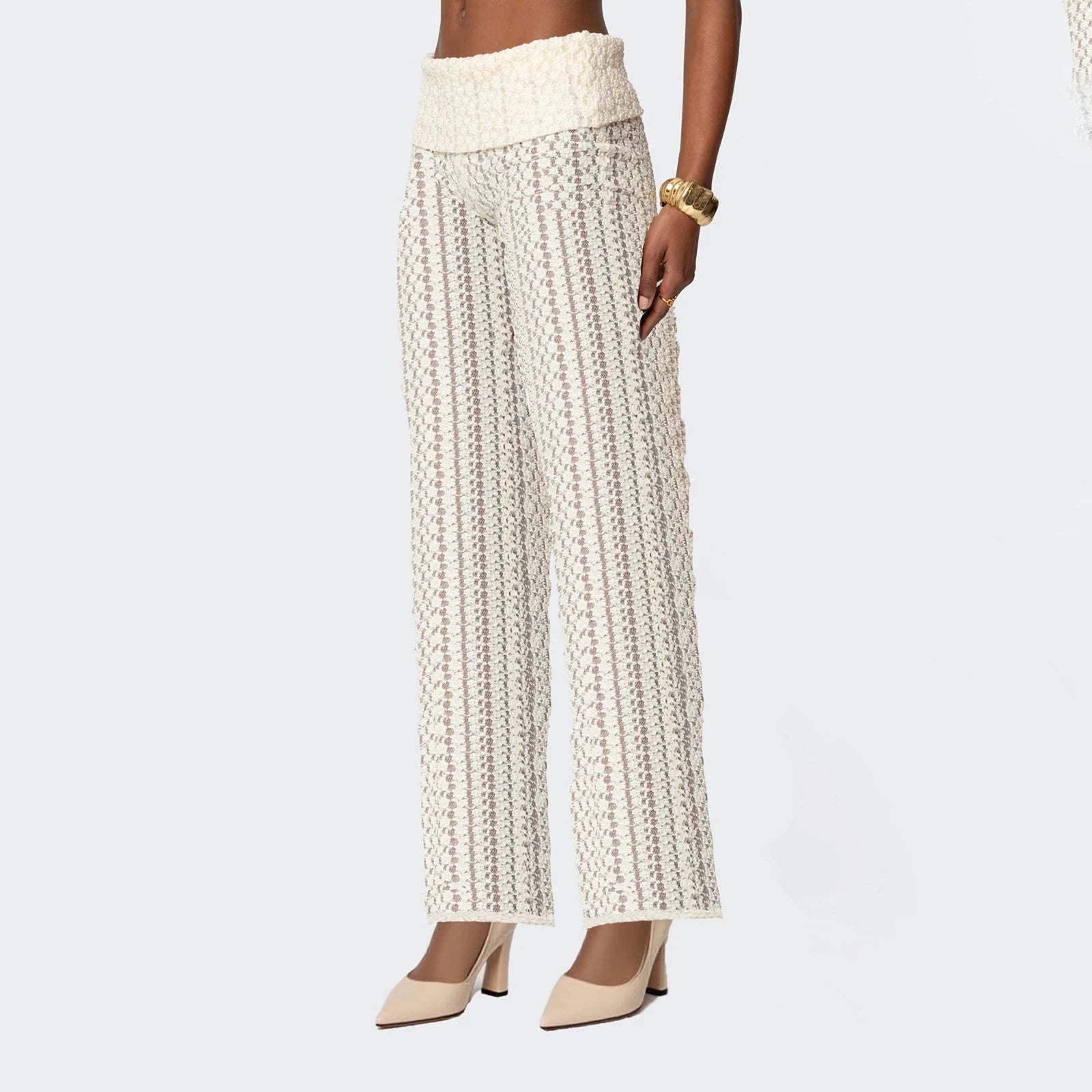 Person wearing a patterned white pants on a light gray background