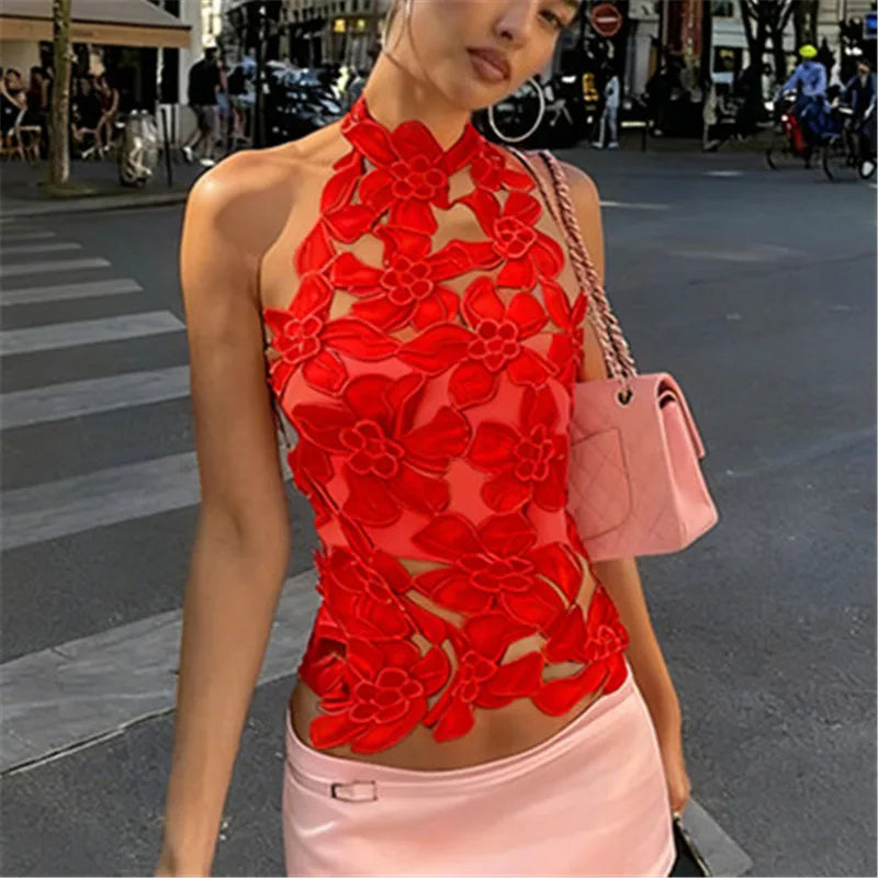 Woman wearing a red floral top and pink skirt on a city street.