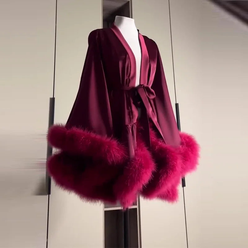 Maroon robe with pink fur trim on a mannequin against a neutral background