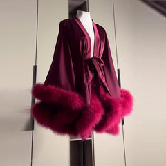 Maroon robe with pink fur trim on a mannequin against a neutral background