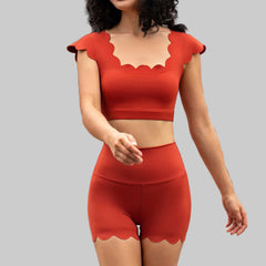 Person wearing a red outfit with scalloped edges in an outdoor setting.