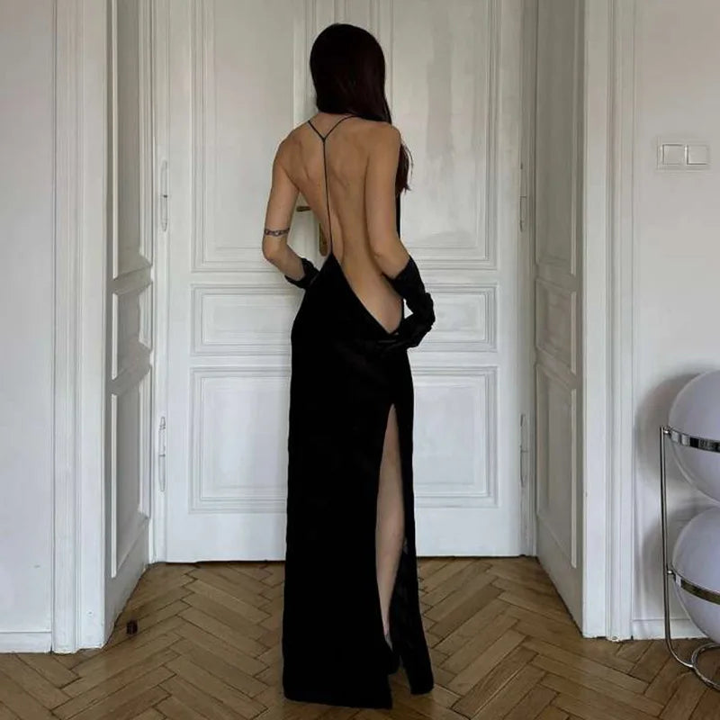  A black striped mesh sheer maxi dress with an open back, halter neckline, and spaghetti straps for a bold evening look.