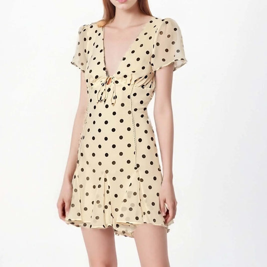 Beige dress with black polka dots on a white background