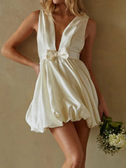 Woman wearing a white dress holding flowers 
