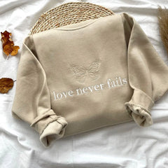 Women's embroidered sweatshirt with a butterfly and inspirational message.