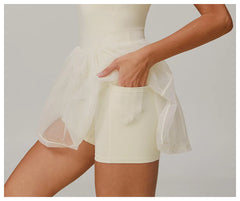 Person wearing a white outfit with sheer overlay - close-up, pocket details