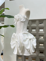 White corset-style dress on a mannequin against a geometric-patterned wall.