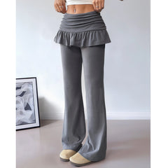 Gray ruffled pants worn by a person on a plain background