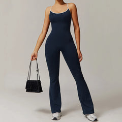 Person wearing a navy jumpsuit holding a black handbag