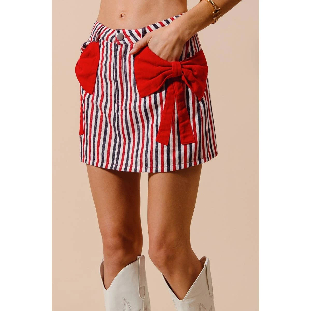 Red, white, and blue striped skirt with a bow detail on a beige background