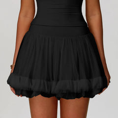 Black skirt worn by a person on a plain background