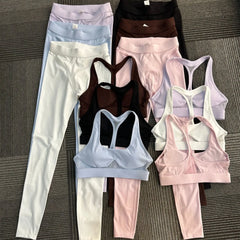 Set of athletic wear including leggings and sports bras on a textured surface