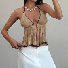 Woman wearing a beige crochet top with black trim 