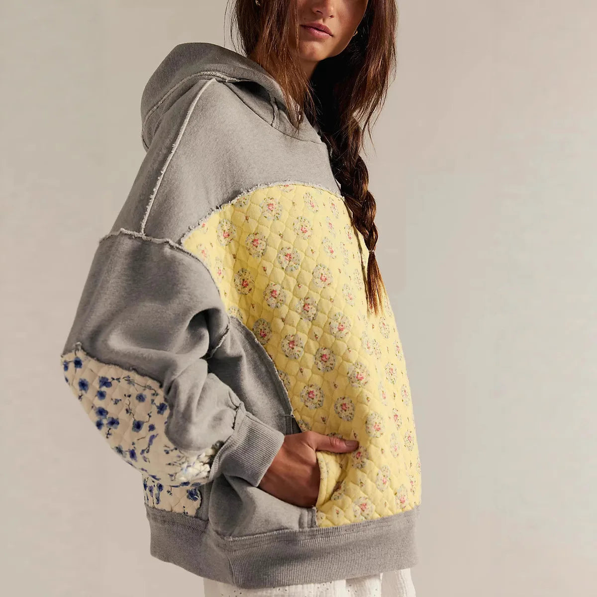 Person wearing a gray and yellow hoodie with floral patterns