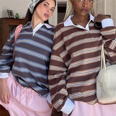 Two women wearing striped shirts with a neutral background