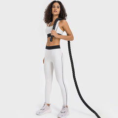 Woman in white athletic wear holding a black rope