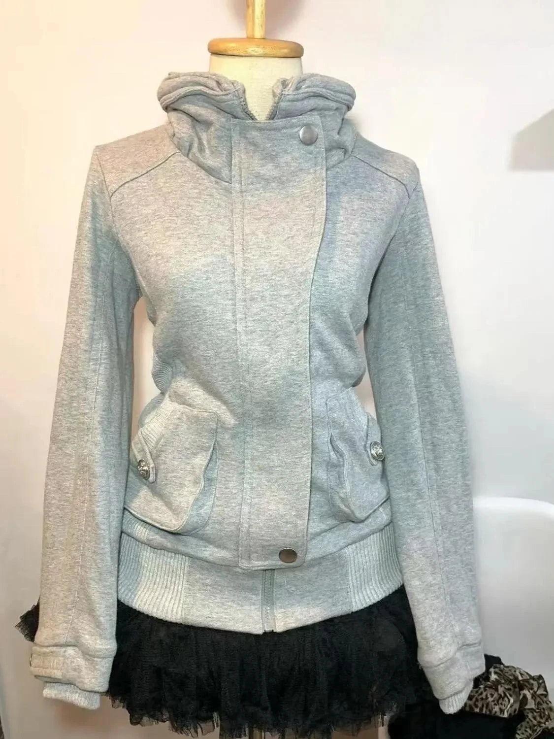 Light blue and gray jacket with a black skirt on a mannequin against a white background