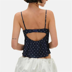 Navy blue polka dot top with cutout design worn by a person