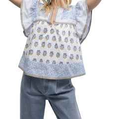 Person wearing a floral apron over a light blue dress