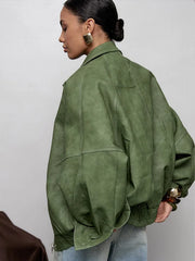 Person wearing a green leather jacket against a plain background