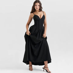 A woman wearing a flattering black maxi dress with a flowing silhouette, perfect for a special occasion or a night out.