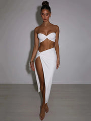 Woman wearing a white strapless top and skirt against a plain background