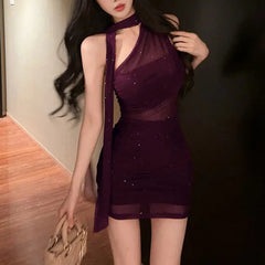 Woman wearing a dark purple dress with sheer panels indoors.