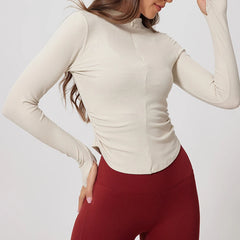 Woman wearing a beige long-sleeve top and red pants