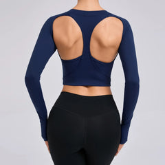 Navy blue long-sleeve crop top with open back and black leggings on a gray background