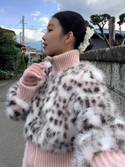 Person wearing a pink sweater and leopard print coat outdoors
