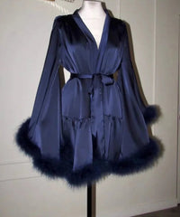 Blue robe with fur trim on a mannequin against a white wall.