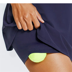 Navy blue athletic shorts with a bright green ball peeking out 