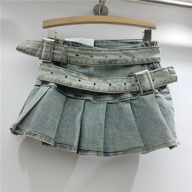 Denim skirt with multiple belts on a hanger against a white background