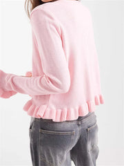 Pink sweater with ruffled hem worn by a person 