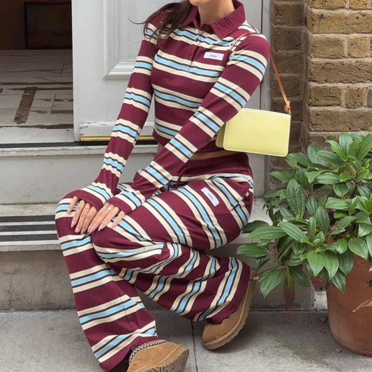 Person wearing a maroon and blue striped outfit sitting on steps with a yellow bag.