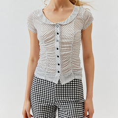 Woman wearing a polka dot blouse and checkered pants 