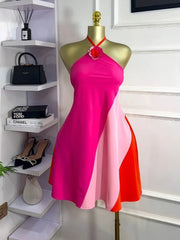 Mannequin wearing a pink and red dress in a room with shelves and shoes.