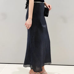 Person wearing a black and white polka dot skirt 