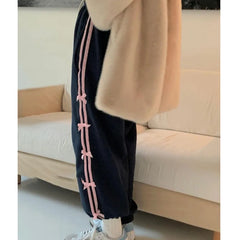 A pair of comfortable joggers with a cute bow accent and a drawstring waist, featuring a stylish striped print.