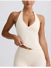 Woman wearing a white halter neck dress against a light gray background