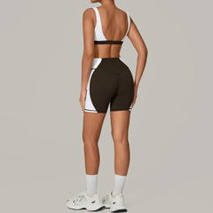 Person wearing a black and white sports outfit with white sneakers- back view