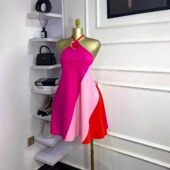 Mannequin wearing a pink and red dress in a room with shelves and decor.